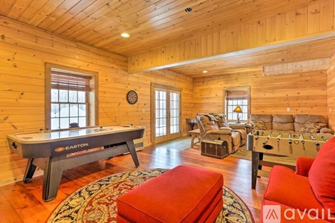 A room with wooden walls and a pool table.