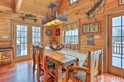 A wooden dining room with a table and chairs.