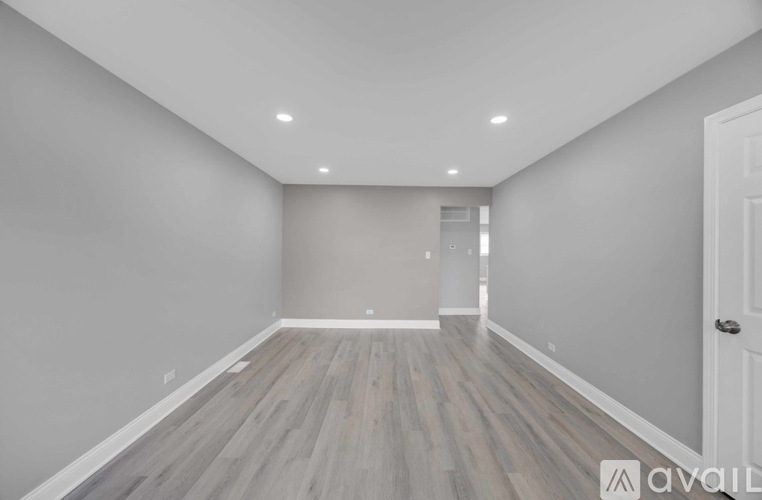 A room with wooden flooring and white walls.