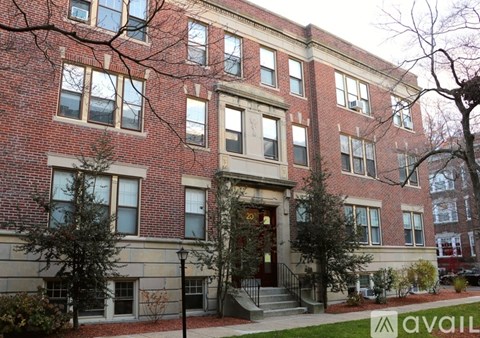 A red brick building with a green lawn in front.