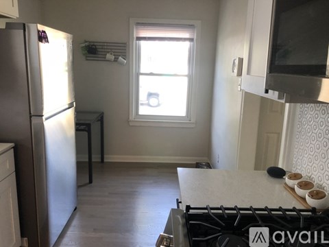 A kitchen with a refrigerator, stove, and microwave.