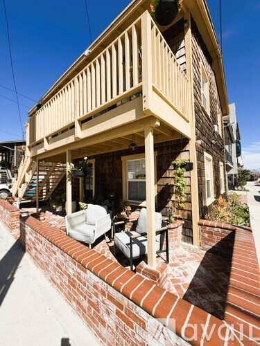 A house with a balcony and a brick wall.