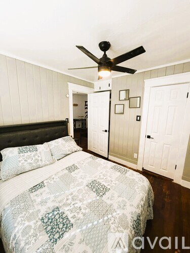 A bedroom with a bed and a ceiling fan.