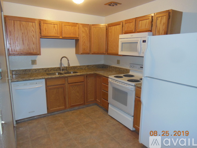 A kitchen with wooden cabinets and white appliances.