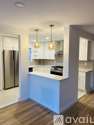 A kitchen with a white counter and a refrigerator.