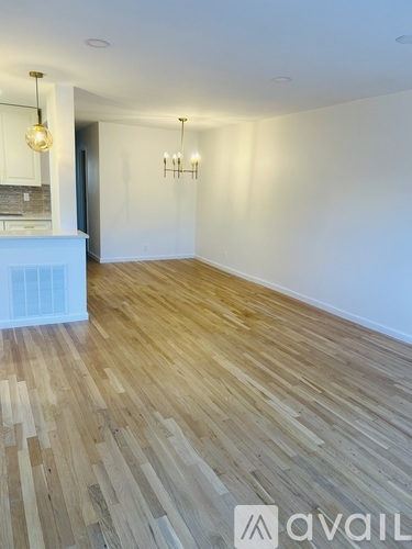 A room with wooden flooring and a white wall.