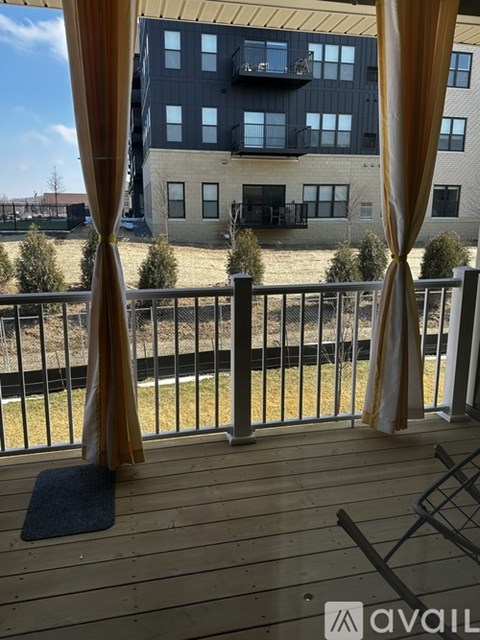 A balcony with a view of a building and trees.