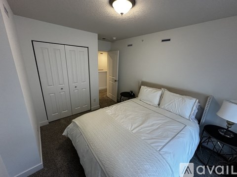 A bedroom with a bed, nightstand, and a lamp.