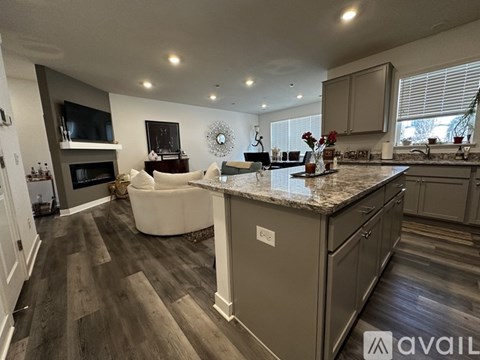 A modern kitchen with a large island and a living area with a couch.