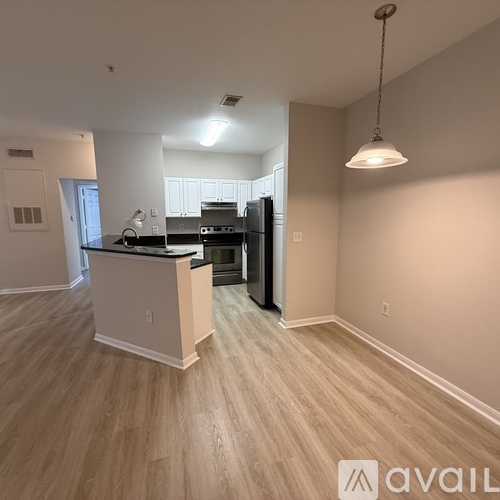 A kitchen with a black fridge and a white island.