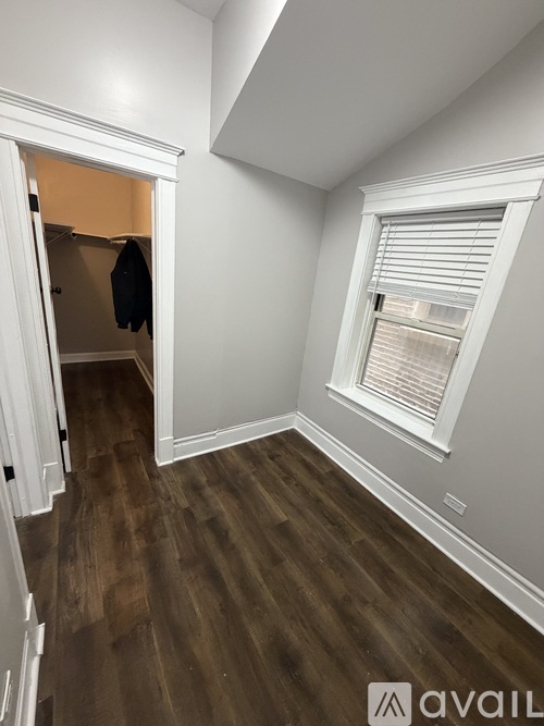 A room with a window and wooden floors.
