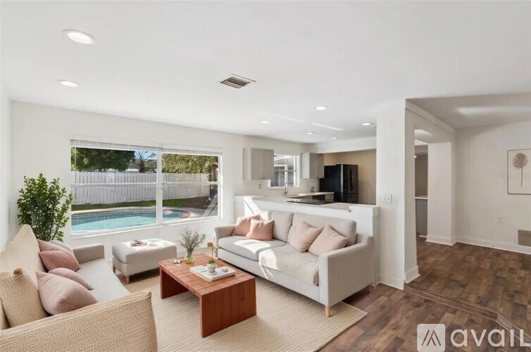 A living room with a white couch and a wooden coffee table.