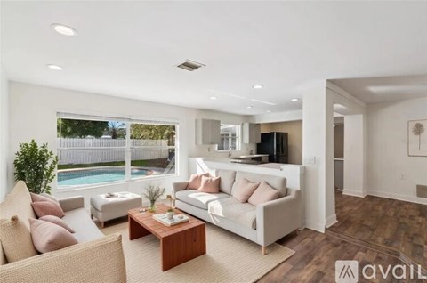 A living room with a white couch and a wooden coffee table.