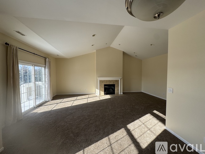 A spacious living room with a fireplace and large windows.