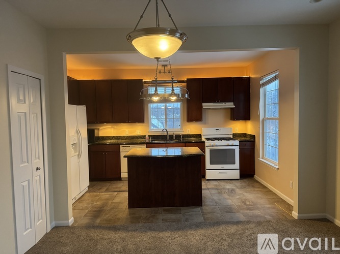 A kitchen with brown cabinets and a white refrigerator.