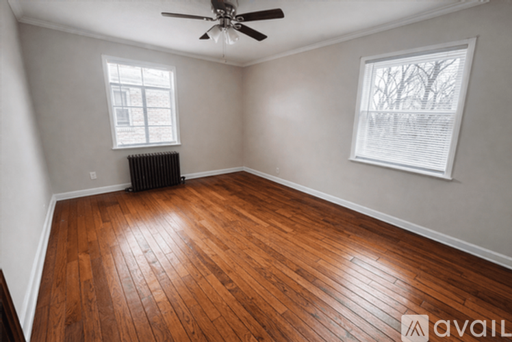 A room with wooden floors and a ceiling fan.