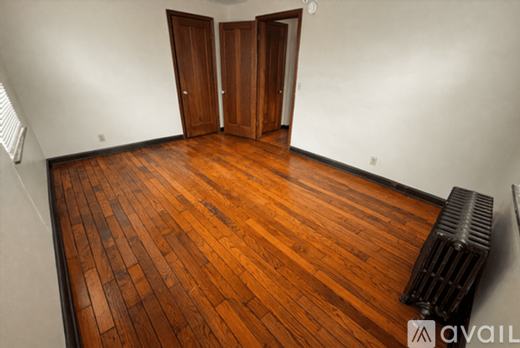 A room with wooden floors and two doors.
