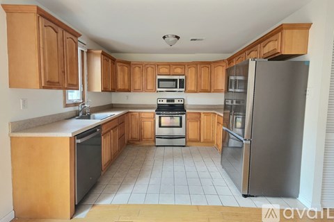 A kitchen with wooden cabinets and stainless steel appliances.