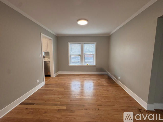 A room with wooden flooring and a window.