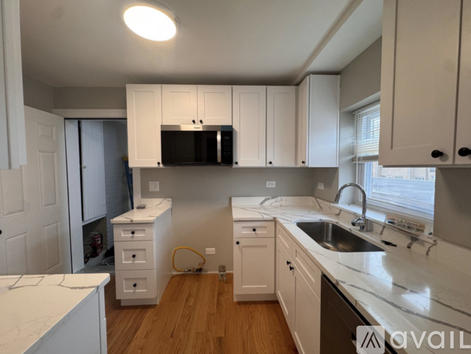 A kitchen with white cabinets and a sink.