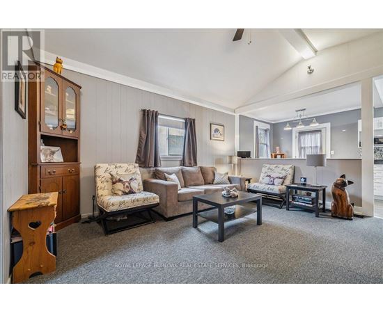 A living room with a grey carpet and furniture.