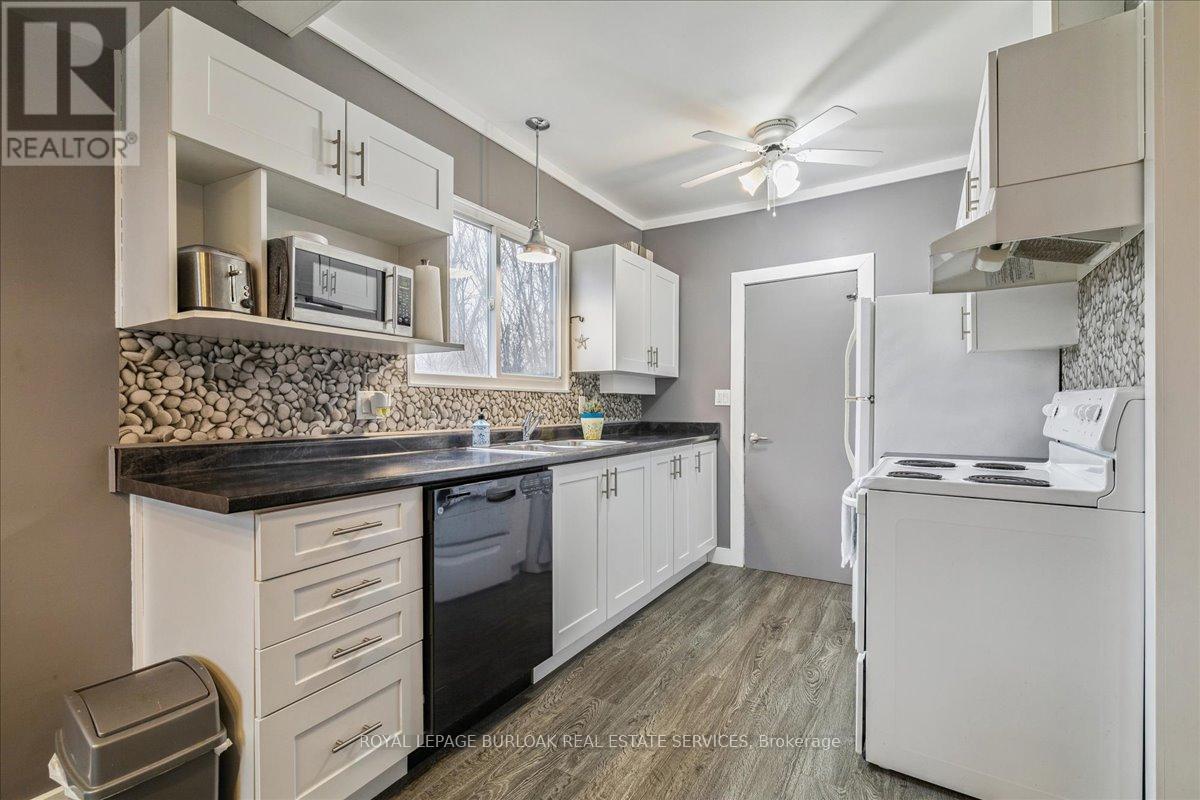 A kitchen with white cabinets and a black countertop.