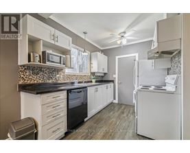 A kitchen with white cabinets and a black countertop.