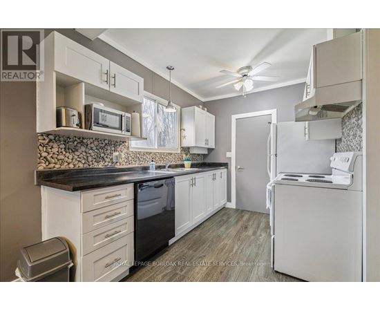 A kitchen with white cabinets and a black countertop.