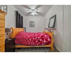A bedroom with a bed covered in a red and white polka dot comforter.