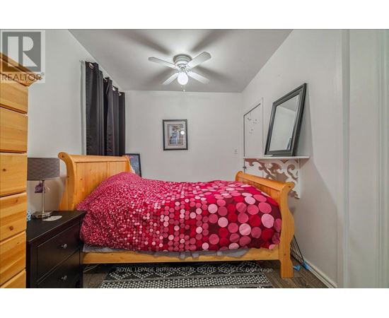 A bedroom with a bed covered in a red and white polka dot comforter.