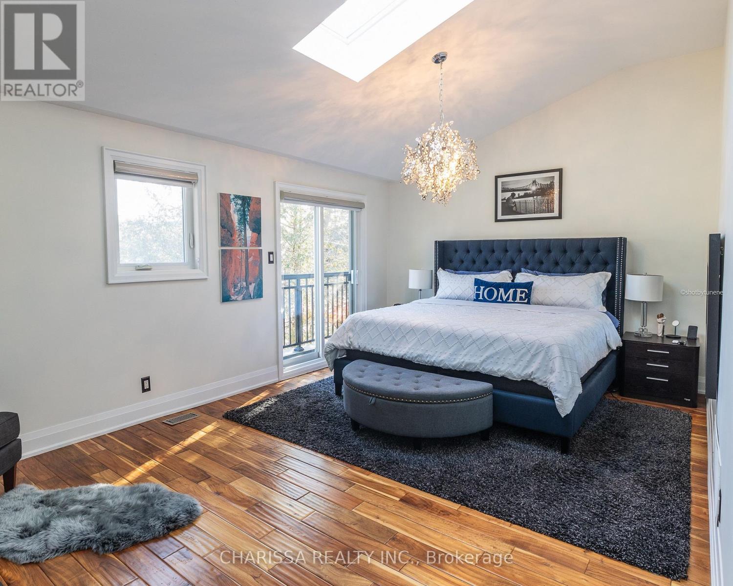 A bedroom with a large bed and a chandelier.