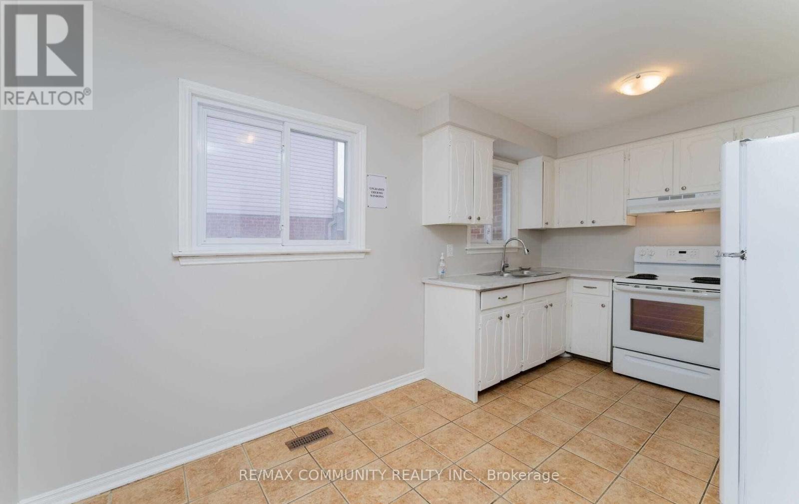 A kitchen with white appliances and cabinets.