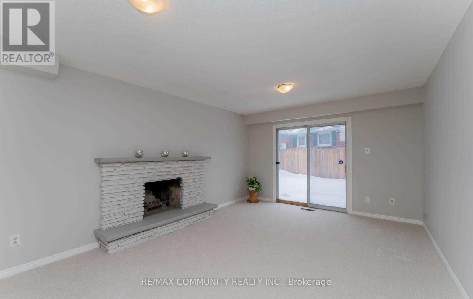 A spacious living room with a fireplace and sliding glass doors.