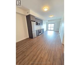 A kitchen with a refrigerator, microwave, and oven.