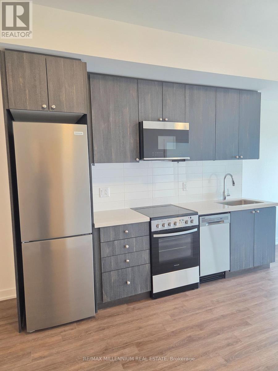 A modern kitchen with a stainless steel refrigerator and oven.