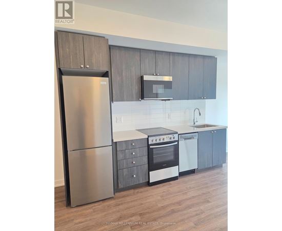 A modern kitchen with a stainless steel refrigerator and oven.