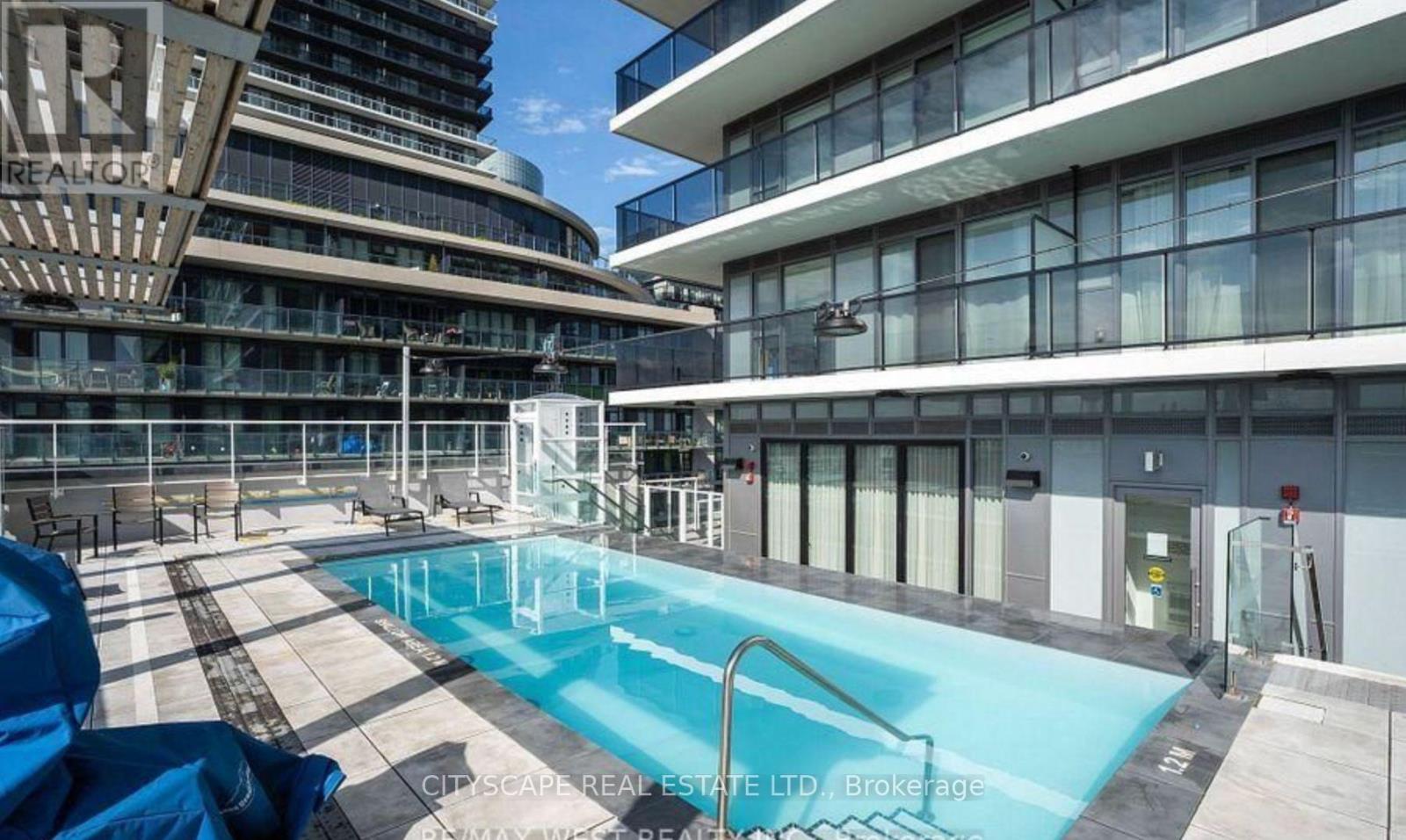 A swimming pool in a courtyard surrounded by buildings.