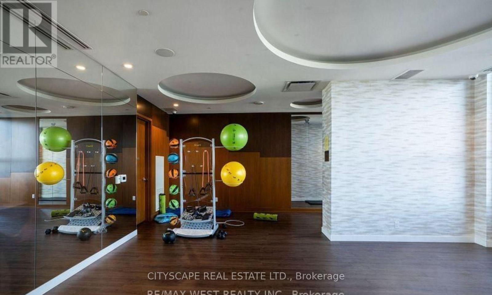 A spacious room with exercise equipment and a large mirror on the wall.