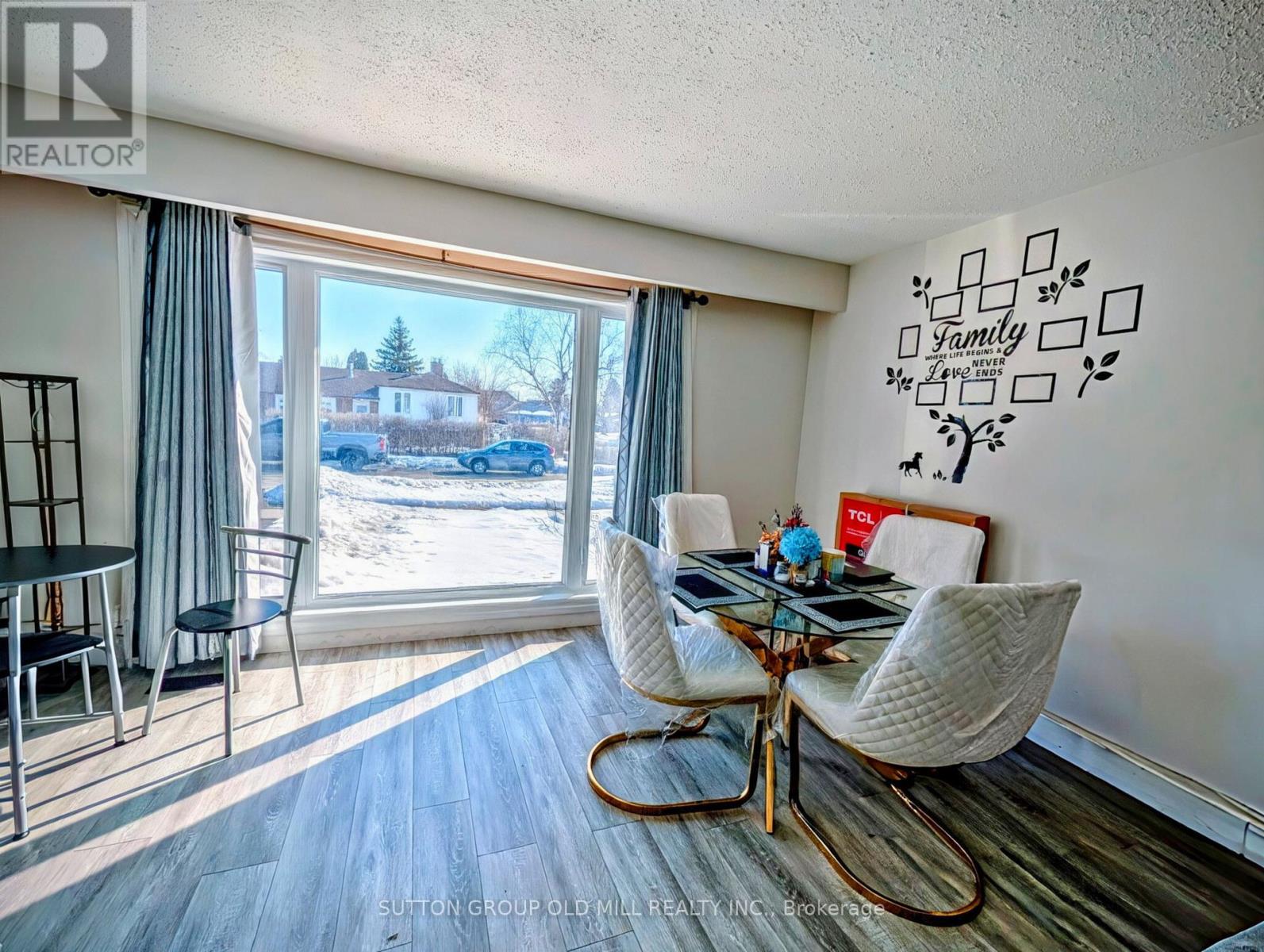 A dining room with a view of a snowy landscape outside the window.