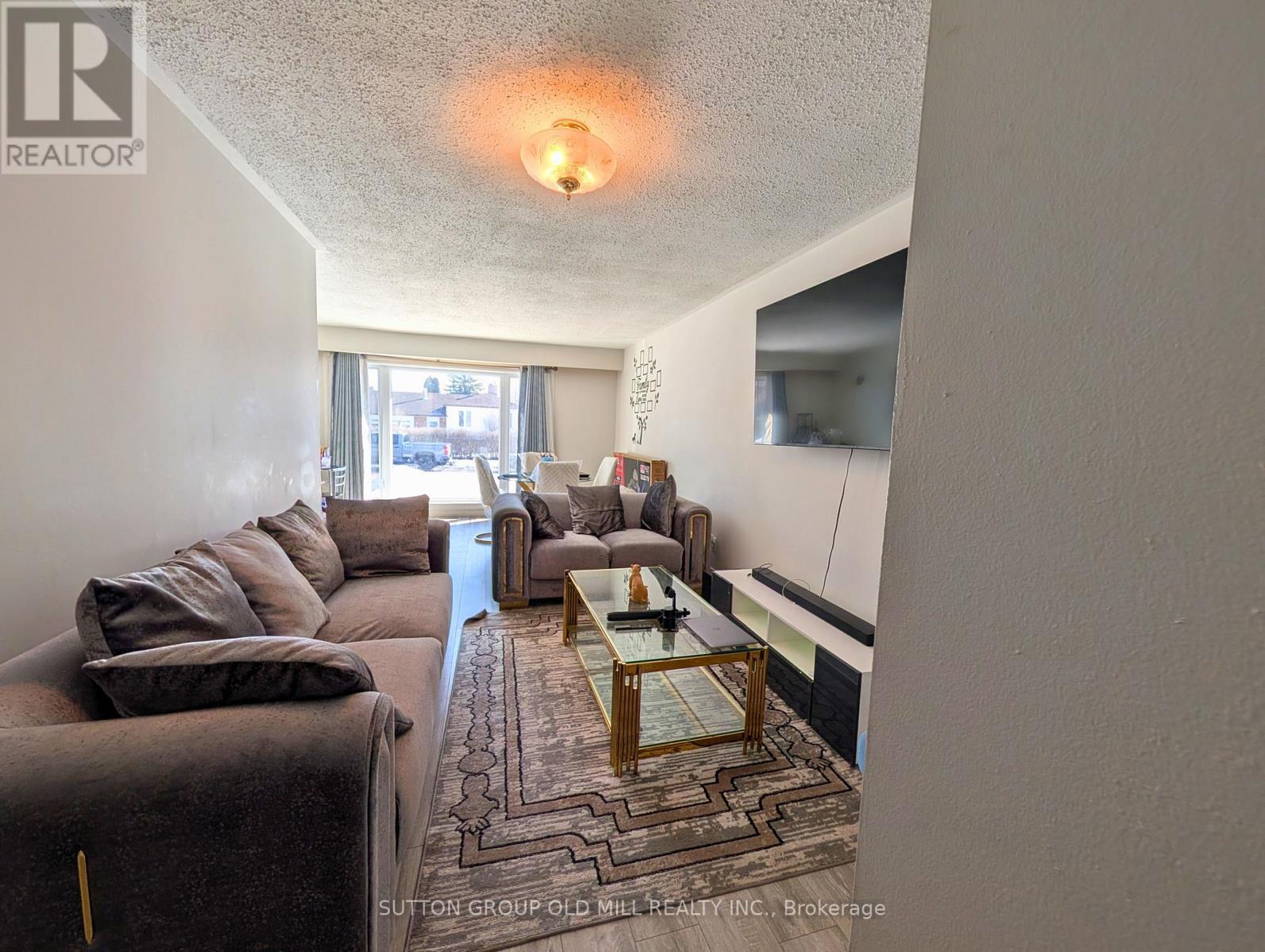 A living room with a brown couch and a glass coffee table.
