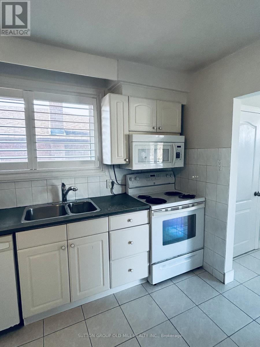 A kitchen with white cabinets and black countertops.