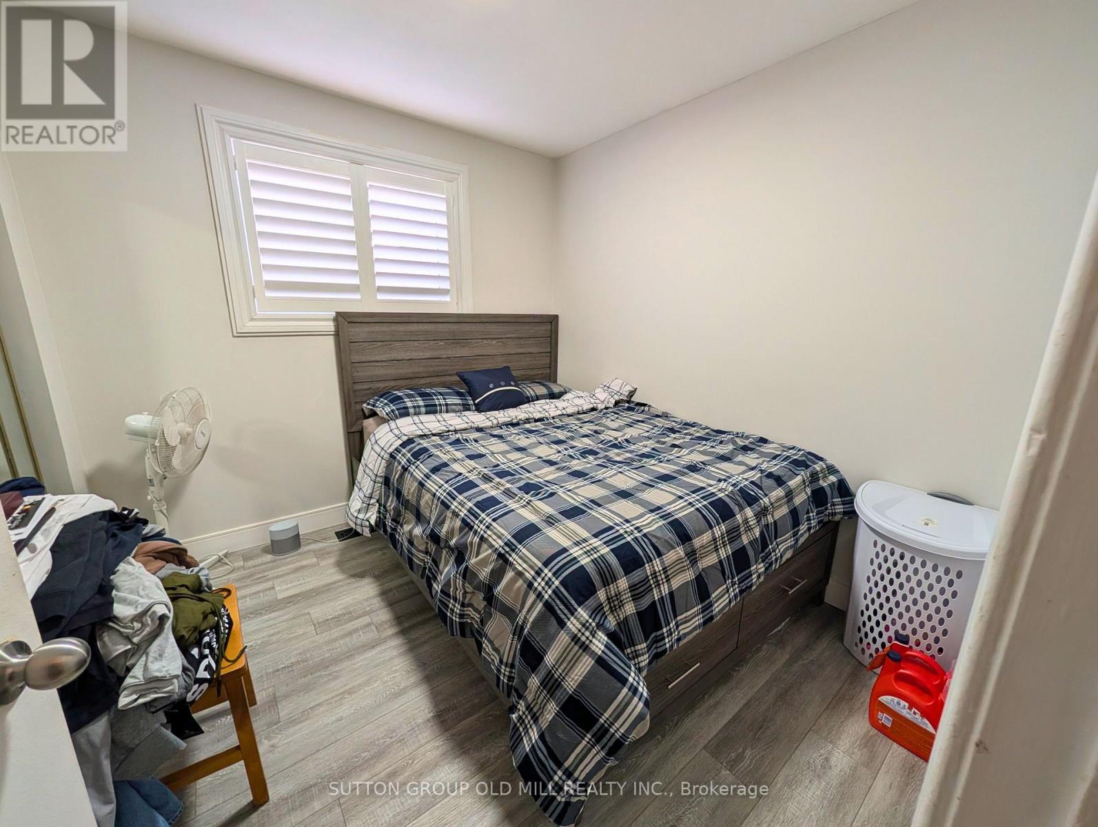A bedroom with a bed, a chair, and a window.