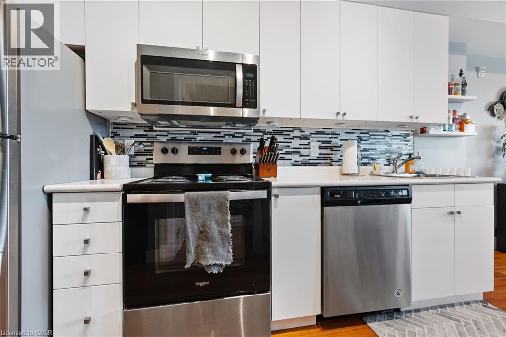 A modern kitchen with white cabinets and stainless steel appliances.