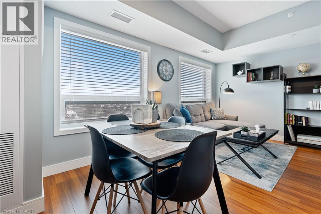 A dining room with a table set for two and a large window with blinds.