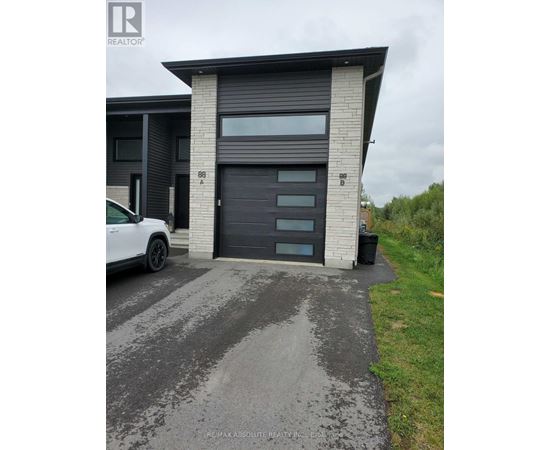 A white car is parked in front of a modern house with a black garage door.