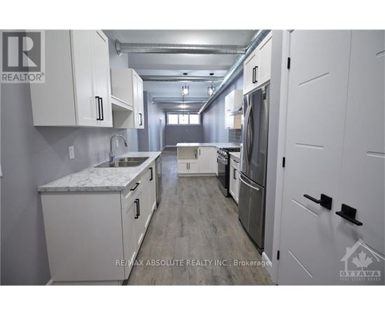 A kitchen with white cabinets and a marble countertop.