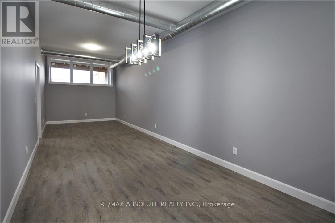 A room with a window and a light fixture hanging from the ceiling.
