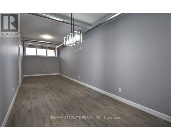 A room with a window and a light fixture hanging from the ceiling.