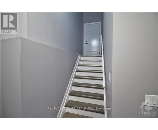 A staircase in a house with a white door at the top.