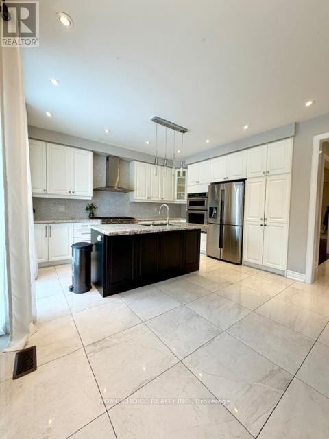 A spacious kitchen with white cabinets and a black island.